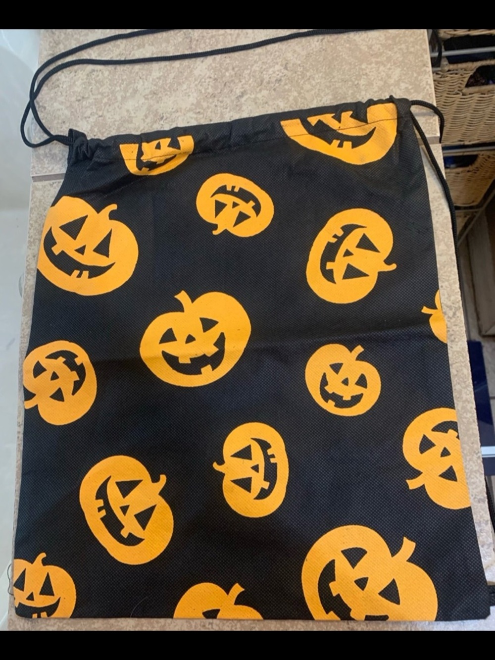 Black Drawstring Sackpack features a repetitive orange Jack-o'-Lantern pattern.